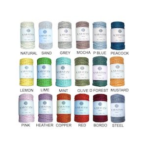 Peut inclure: Une collection de 18 bobines de cordon en coton de différentes couleurs, notamment naturel, sable, gris, moka, bleu, paon, citron, vert lime, menthe, olive, forêt, moutarde, rose, bruyère, cuivre, rouge, bordeaux et acier. Chaque bobine est étiquetée avec le nom de la couleur et "Kabatani Twist".