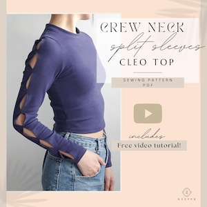 May include: A crew neck Cleo top in a deep blue hue, featuring split sleeves. The long-sleeved top is paired with blue jeans. The image includes text that reads "CREW NECK split sleeves CLEO TOP" and "SEWING PATTERN PDF".