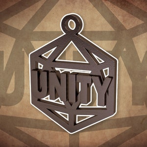 Könnte beinhalten: Ein brauner Metallanhänger in Form eines geometrischen Würfels mit dem Wort "UNITY" auf der Vorderseite. Der Anhänger hat eine Öse oben zum Aufhängen.
