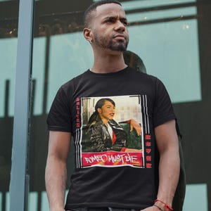 May include: Black t-shirt featuring a framed image of a woman in a leather jacket and the text "ROMEO MUST DIE". The image has red and white accents and vertical text on the sides.