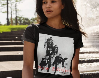 Pode incluir: Fotografia em preto e branco de um grupo de homens usando chapéus e ternos. A foto está em uma camiseta preta com as palavras "New Edition" e "Home Again" em texto vermelho.