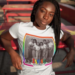 May include: White t-shirt with a rainbow border around a black and white photo of a group of people. The text "Living Single" is printed below the photo.