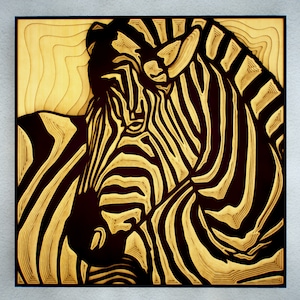 Pode incluir: Uma peça de arte em madeira em camadas preta e dourada que representa a cabeça e o pescoço de uma zebra. As listras da zebra são sobrepostas para criar um efeito 3D.