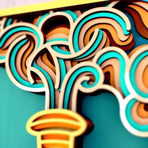 May include: Abstract paper art sculpture with swirling, layered shapes in shades of teal, brown, and yellow. The sculpture is reminiscent of a stylized wave or water fountain.