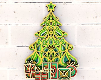 May include: A green and gold paper Christmas tree with intricate cut-out designs. The tree is decorated with a star on top and surrounded by small, colorful gift boxes.