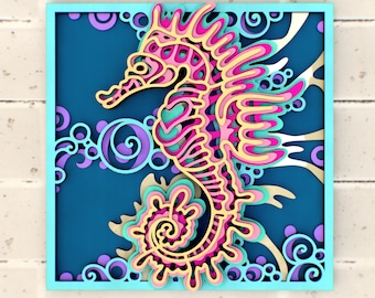 May include: A pink and yellow paper cut-out of a seahorse with intricate details, set against a blue background with swirling patterns.