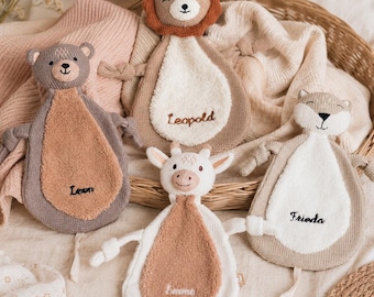 Puede incluir: Cuatro mantitas de apego de punto con forma de oso llamado Leon, león llamado Leopold, jirafa llamada Emma y zorro llamado Frieda. Cada peluche presenta un panel central con textura y brazos con nudos en los extremos.