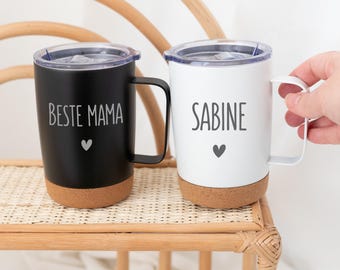 Könnte beinhalten: Zwei Edelstahl-Reisebecher mit Korkboden. Ein Becher ist schwarz mit dem Text "Beste Mama" und einem Herz. Der andere Becher ist weiß mit dem Text "Sabine" und einem Herz.