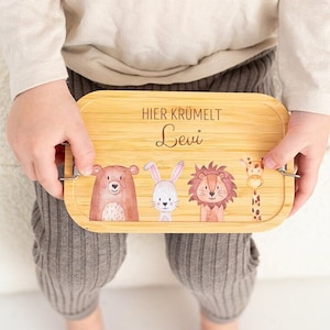 Puede incluir: Una bandeja de madera con una ilustraci&oacute;n de un oso, un conejo, un le&oacute;n y una jirafa. La bandeja tiene el texto "Hier kr&uuml;melt Levi" grabado.