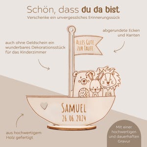 May include: Wooden sailboat with a bear, rabbit and lion on board. The sailboat has a flag that says "Alles Gute Zur Taufe". The sailboat is engraved with the name "Samuel" and the date "26.06.2024".