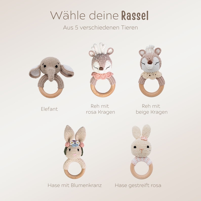 K&ouml;nnte beinhalten: F&uuml;nf geh&auml;kelte Babyrasseln mit verschiedenen Tierdesigns: Elefant, Reh mit rosa Kragen, Reh mit beigefarbenem Kragen, Hase mit Blumenkranz und gestreiftem Hasen. Der Text "W&auml;hle deine Rassel" und "Aus 5 verschiedenen Tieren" ist sichtbar.