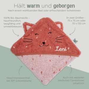May include: A coral-colored hooded baby towel with a cat face design. The towel is made of soft, absorbent cotton and features the name "Leni". The towel is available in two sizes: 75 x 75 cm or 70 x 130 cm.