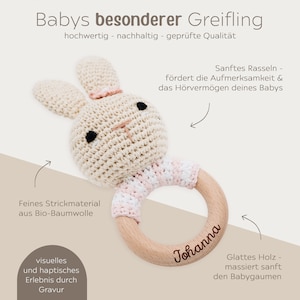 K&ouml;nnte beinhalten: Ein geh&auml;keltes Hasenrassel mit einem Holzring. Der Ring ist mit dem Namen "Johanna" graviert. Die Rassel ist aus Bio-Baumwolle gefertigt und hat ein weiches, nat&uuml;rliches Gef&uuml;hl.