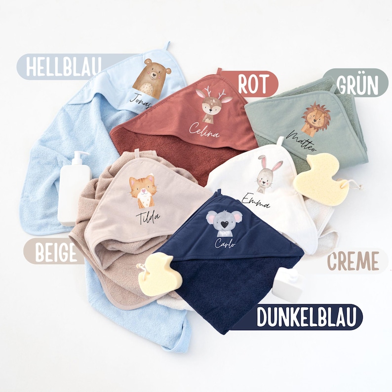 May include: Assortment of hooded towels in various colors, including beige, light blue, red, green, cream, and dark blue. Each towel features a different animal design and a personalized name, such as "Jonas", "Celina", "Matteo", "Tilda", "Emilda", and "Carlo".