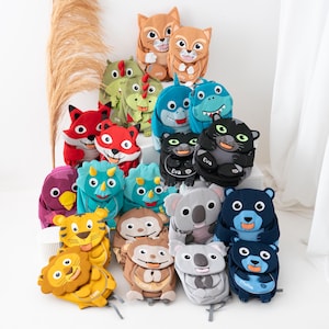 Peut inclure: Collection de sacs à dos pour enfants en forme d'animaux en peluche. Les modèles incluent un renard, un chat, un dinosaure, un requin, un ours, un koala, un lion, un singe et un oiseau. Chaque sac a un visage d'animal unique.