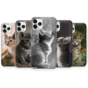 Op de afbeelding: Vijf verschillende iPhone-hoesjes met afbeeldingen van schattige kittens. De hoesjes zijn transparant en laten de camera van de telefoon zien. De kittens zijn in verschillende poses en kleuren, waaronder zwart-wit, tabby en grijs.