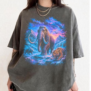 Vintage T-shirt wolharige mammoet, jaren 90 ijstijd dieren grafisch T-shirt, comfort kleuren shirt sabeltandtijger, prehistorische natuur kunst T-shirt