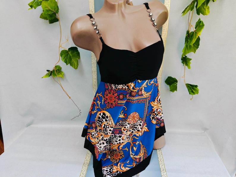 Puede incluir: Top negro con falda estampada en azul, naranja y dorado. El top tiene tirantes de pedrer&iacute;a y escote coraz&oacute;n. La falda presenta un dise&ntilde;o barroco con detalles de estampado de leopardo. La prenda se exhibe en un maniqu&iacute;.
