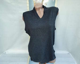 Puede incluir: Un chaleco sin mangas de color gris carbón con cuello en V. El chaleco se exhibe en un maniquí. La tela parece ser un tejido de punto suave. El chaleco tiene un diseño clásico y sencillo, adecuado para usar en capas o solo.