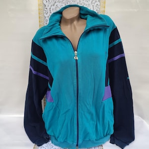 May include: A blue and black zip-up jacket with purple accents. The jacket has a high collar and a zipper closure.