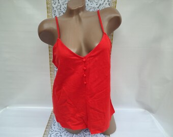 May include: A bright red sleeveless top with a button-down front. The top has a V-neckline and a relaxed fit.