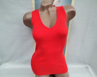 May include: A vibrant red, ribbed knit tank top with a deep V-neck. The sleeveless top is displayed on a mannequin, showcasing its form-fitting design. The fabric has vertical ribbing, adding texture to the garment. A simple, yet stylish piece.