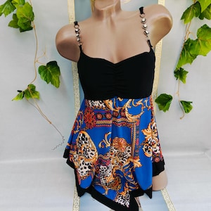 Puede incluir: Top negro con escote coraz&oacute;n y tirantes de cadena. La parte inferior es de tela azul estampada con detalles dorados y rojos. El dise&ntilde;o incluye un estampado de leopardo y detalles ornamentados. La parte superior se muestra en un maniqu&iacute;.
