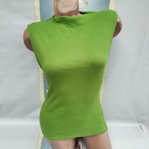 May include: A sleeveless, lime green top with a high neckline. The top is made of a soft, ribbed knit fabric and has a fitted silhouette. The garment is displayed on a mannequin.