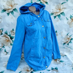 May include: A light blue hooded jacket with gold buttons and pockets.