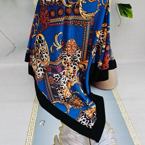 Puede incluir: Un pa&ntilde;uelo azul con borde negro, con un dise&ntilde;o barroco con detalles dorados, rojos y blancos. El pa&ntilde;uelo tiene un estampado de leopardo y un dise&ntilde;o de cadena.