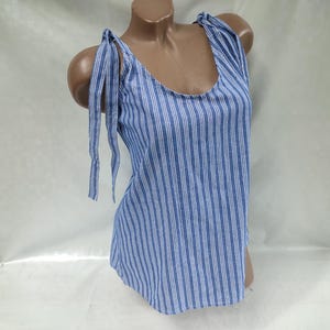 May include: A blue and white striped sleeveless top with thin straps that tie at the shoulders.