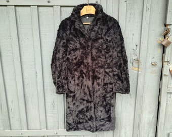 May include: A long black faux fur coat with a collar and a button closure.