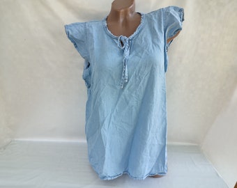May include: Light blue denim top with ruffled cap sleeves and a tie-up neckline. The top is sleeveless and has a relaxed fit. The fabric appears to be lightweight and suitable for warm weather.