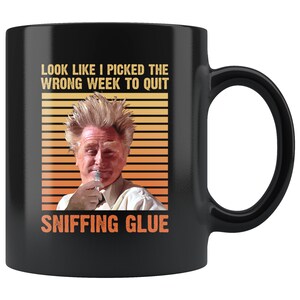 May include: Black coffee mug with a retro-style design featuring a man with spiky hair and the text "Look like I picked the wrong week to quit sniffing glue."