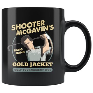 Puede incluir: Taza de café de cerámica negra con un gráfico blanco de un golfista balanceando un palo. El gráfico incluye el texto "Shooter McGavin's", "Bang Bang", y "Gold Jacket Golf Tournament 1996".
