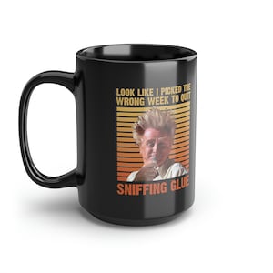 May include: Black coffee mug with a white graphic of a man with spiky hair and the text "Look like I picked the wrong week to quit sniffing glue".