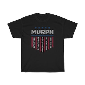 May include: Black t-shirt with a red, white, and blue American flag design. The text "MURPH" is printed in blue on the flag. The text "1 MILE RUN", "100 PULL-UPS", "200 PUSH-UPS", "300 SQUATS", and "1 MILE RUN" is printed vertically on the flag.