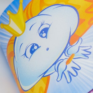 May include: A blue cartoon character with a crown and a yellow and orange cape. The character has large blue eyes and a big smile. The background is blue with white rays of light.