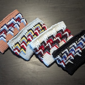May include: Five crocheted zipper pouches in different colors with a zig-zag pattern. The pouches are made with a variety of colors including black, white, gray, blue, red, and yellow.