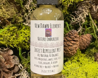 May include: A clear glass bottle with a black spray top and a white label. The label reads "New Dawn Elements Nature Embraceor Insect Repellent Mist All Natural & Organic Repels Mosquitoes, Gnats, Ticks, Flies, Fleas, Chiggers, & Spiders Alcohol Free No Deet Natural 2 fl oz (59.15 ml)"