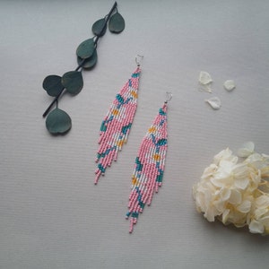 Witte bloemkraaloorbellen Lichtroze rocaillesoorbellen Lange kralenoorbel Bloemen franjeoorbel Daisy kralenoorbel Boho-sieraden met kralen