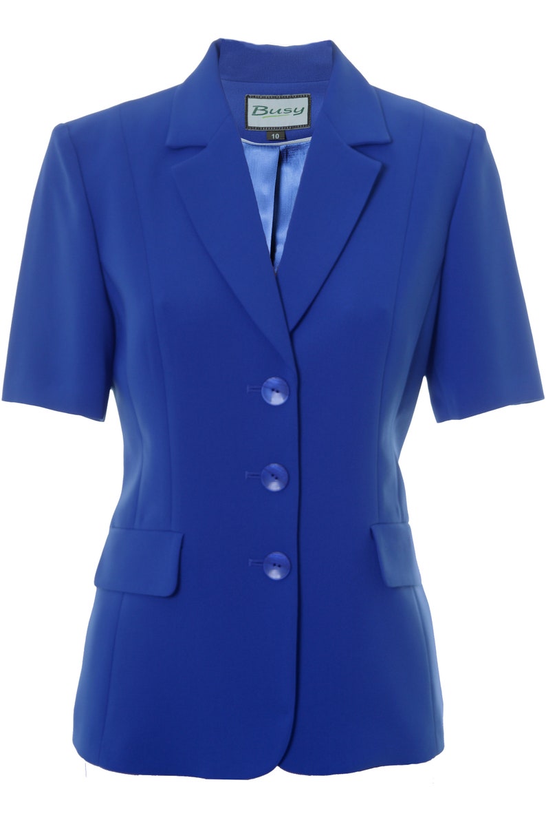 May include: A royal blue blazer with short sleeves and three buttons. The blazer has a pocket on the left side and a label that says "Busy" with the size "10" printed on it.