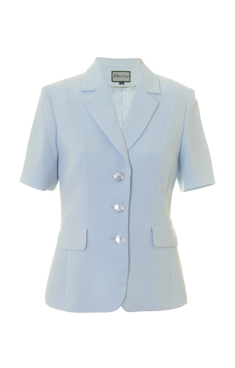 May include: A light blue blazer with short sleeves and four silver buttons. The blazer has a label that says "Busy" on it.