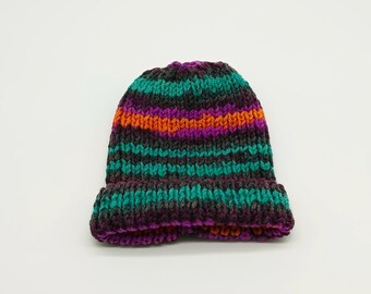 May include: A striped knit beanie hat in shades of purple, teal, orange, and black.