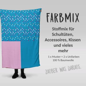 Könnte beinhalten: Ein großer, rechteckiger Stoff mit einem Farbblock-Design. Der obere Teil hat einen türkisfarbenen Hintergrund mit einem Muster aus kleinen rosa, weißen und blauen Punkten. Der untere Teil hat einen rosa und türkisfarbenen Abschnitt. Der Text "FARBMIX" ist sichtbar.