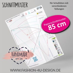 Könnte beinhalten: Ein weißes Papierschnittmuster mit dem Text "SCHNITTMUSTER" und "CUT & SEW". Ein rosa Oval zeigt "Papierschnittmuster 85 cm". Das Muster enthält gestrichelte Linien und die Worte "HANDMADE WITH LOVE".