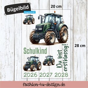 Könnte beinhalten: Ein grün-schwarzes Traktormotiv, 20 cm x 28 cm groß, mit den Texten "Schulkind" und "Du bist erstklassig!". Das Design beinhaltet die Jahre 2026, 2027 und 2028. Das Bild zeigt auch den Text "Bügelbild".