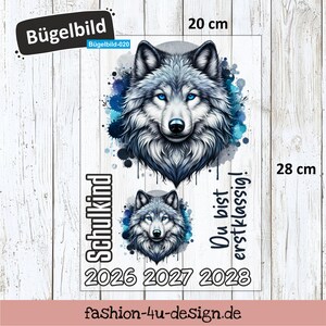 Könnte beinhalten: Ein 20 cm x 28 cm Bügelbild mit einem Wolfsdesign mit blauen Augen und Aquarell-Effekten. Enthält die Texte "Schulkind" und "Du bist erstklassig!" sowie die Jahreszahlen 2026, 2027 und 2028.