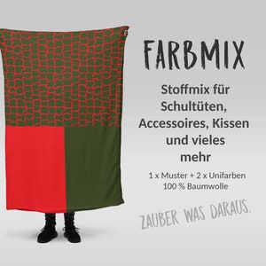 Könnte beinhalten: Ein grüner und roter Stoff mit einem geometrischen Muster. Der Stoff ist in der Hälfte gefaltet und wird von einer Person gehalten. Der Text "FARBMIX" ist in Schwarz auf weißem Hintergrund geschrieben. Der Text "Stoffmix für Schultüten, Accessoires, Kissen und vieles mehr" ist in Schwarz auf weißem Hintergrund geschrieben. Der Text "1 x Muster + 2 x Unifarben 100% Baumwolle" ist in Schwarz auf weißem Hintergrund geschrieben. Der Text "ZAUBER WAS DARAUS." ist in Schwarz auf weißem Hintergrund geschrieben.