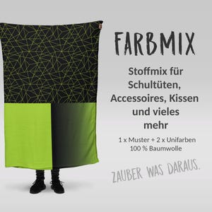 Könnte beinhalten: Eine Person hält ein schwarzes und grünes Stoff mit einem geometrischen Muster hoch. Der Stoff ist mit "FARBMIX Stoffmix für Schultüten, Accessoires, Kissen und vieles mehr 1 x Muster + 2 x Unifarben 100% Baumwolle ZAUBER WAS DARAUS." beschriftet.